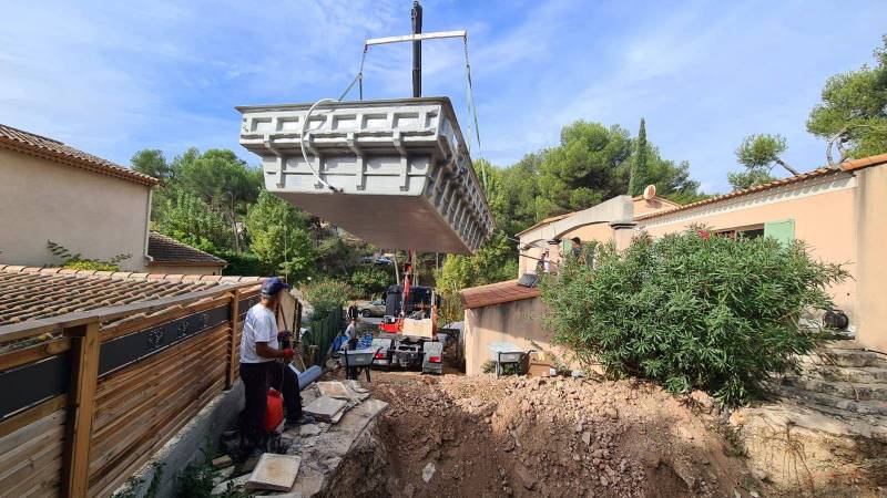Rénovation d'une ancienne piscine de plus de 20 ans avec une structure métallique par une coque polyester Alliance Piscines sur Ventabren.